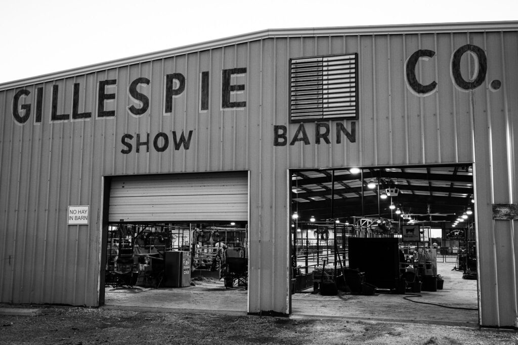 Exterior of Gillespie Co. Show Barn with two open entrances and a No Hay In Barn sign.